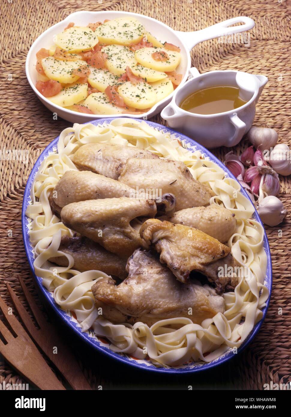 Poulet aux trente gousses d'ail. Chicken cooked with thirty cloves of garlic . . Pommes de terre a la provencale. Mediterranean potato dish Stock Photo