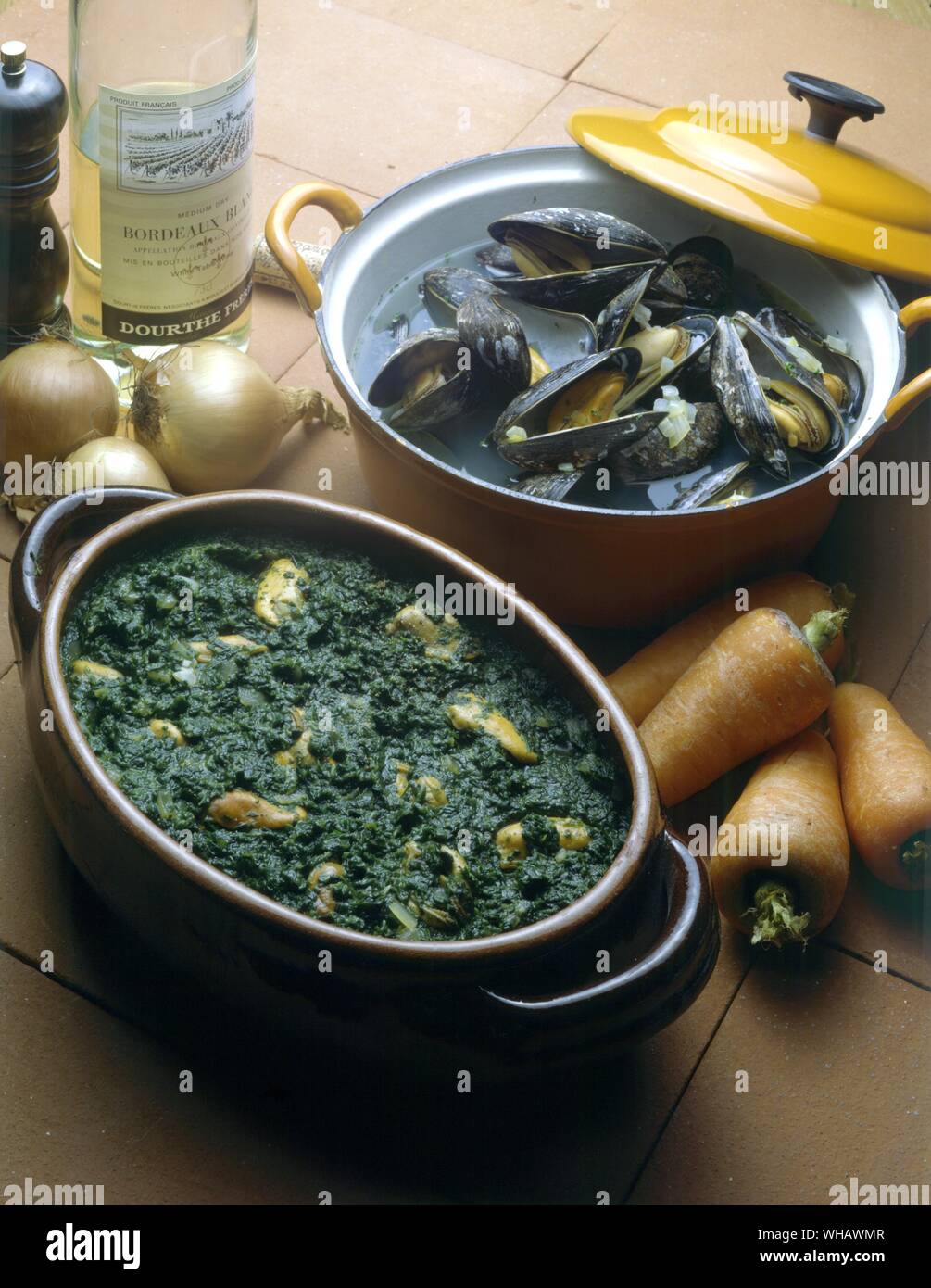 Moules a la mariniere. . Moules aux epinards. Mussels with garlic amd spinach Stock Photo