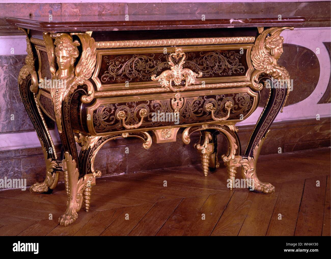 Boulle commode made for Louis XIV room at the Grand Trianon 1701. Rococo carving bowed legs, acanthus leaf decoration, french sphinxes at corners. The Sun King by Nancy Mitford, page 176.. The Grand Trianon is a royal villa situated to the north of the Palace of Versailles gardens, in France. The villa was built in 1687 as a retreat for King Louis XIV of France. Stock Photo