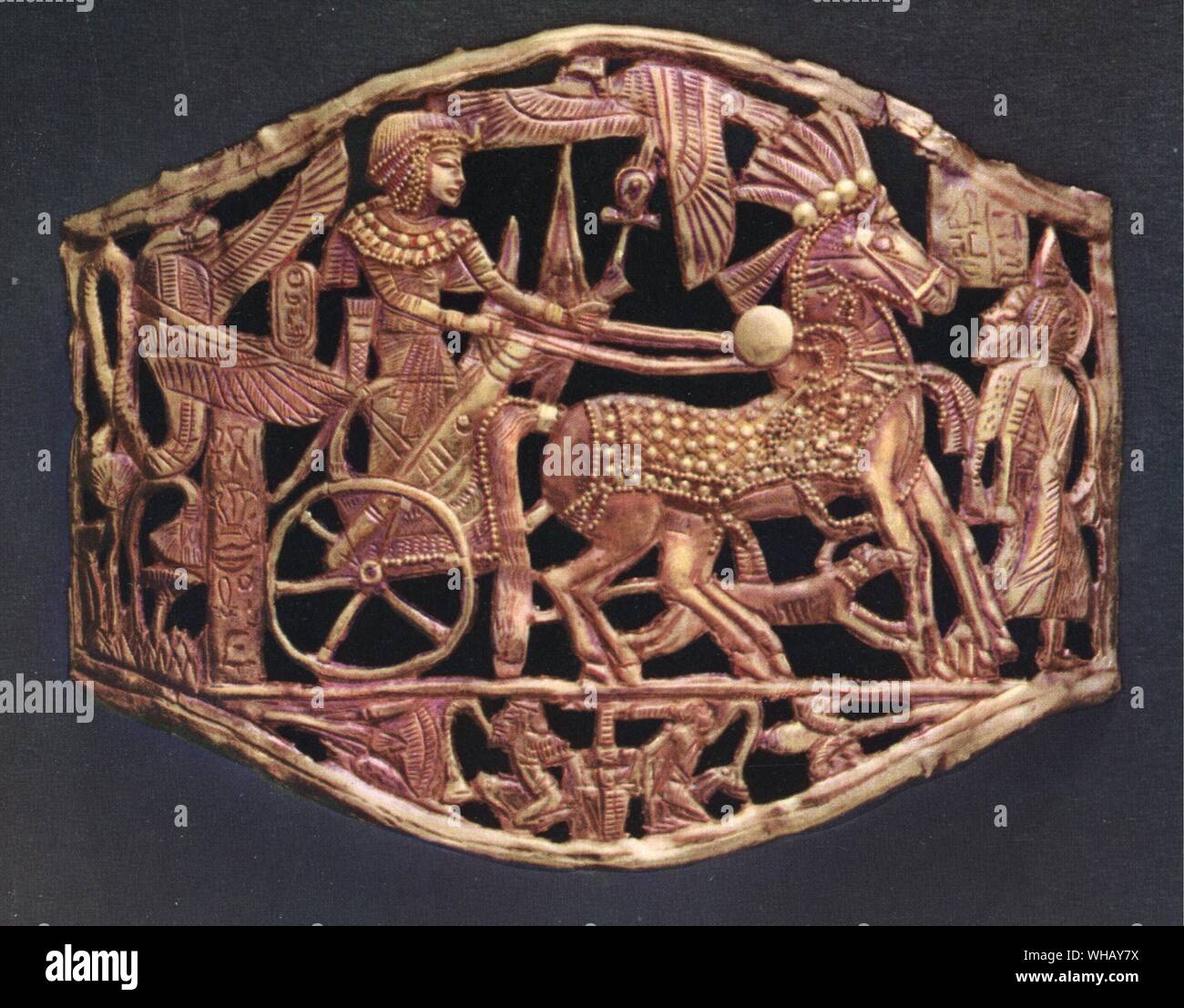 Object in red gold openwork showing the king's triumphant return with prisoners. Tukankhamen, by Christiane Desroches Noblecourt, page 98.. The Egyptian symbol for gold is a collar with beads along the lower edge. Gold has long been associated with the gods and royalty. This imperishable metal reflects the brilliance of the sun and the hope of eternal life. . In the shape of a mirror or a knot, the ankh is a symbol of life. It was often carried by deities or people in a funeral procession, or offered to the king as the breath of life. Here, the Ankh is carried by the vulture top centre.. . . . Stock Photo