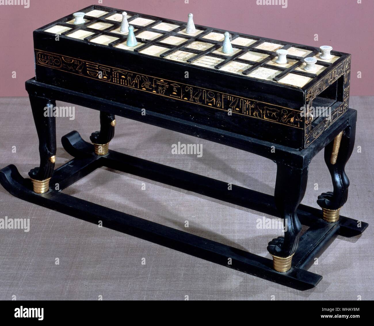 A game of Senet in ebony and ivory. This is the largest of three such objects found in the tomb. Tukankhamen, by Christiane Desroches Noblecourt, page 18.. This game table composed of interlocking pieces. The piece takes the form of a box resting on a base supported by four leonine legs, partially covered with gold leaf and fixed to a sledge. The upper surface is veneered with ivory and is subdivided by means of strips of wood into thirty squares, five of which carry inscriptions. The game of senet was played on this board. There are the same number of squares in ivory on the lower surface of Stock Photo