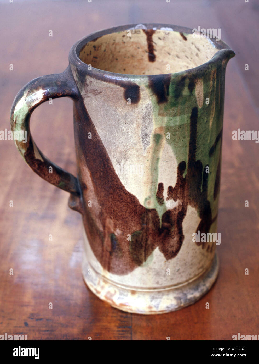 Redware jug coated with cream slip and decorated with brown and green glazes, 19th century.. American Museum in Britain.. Stock Photo