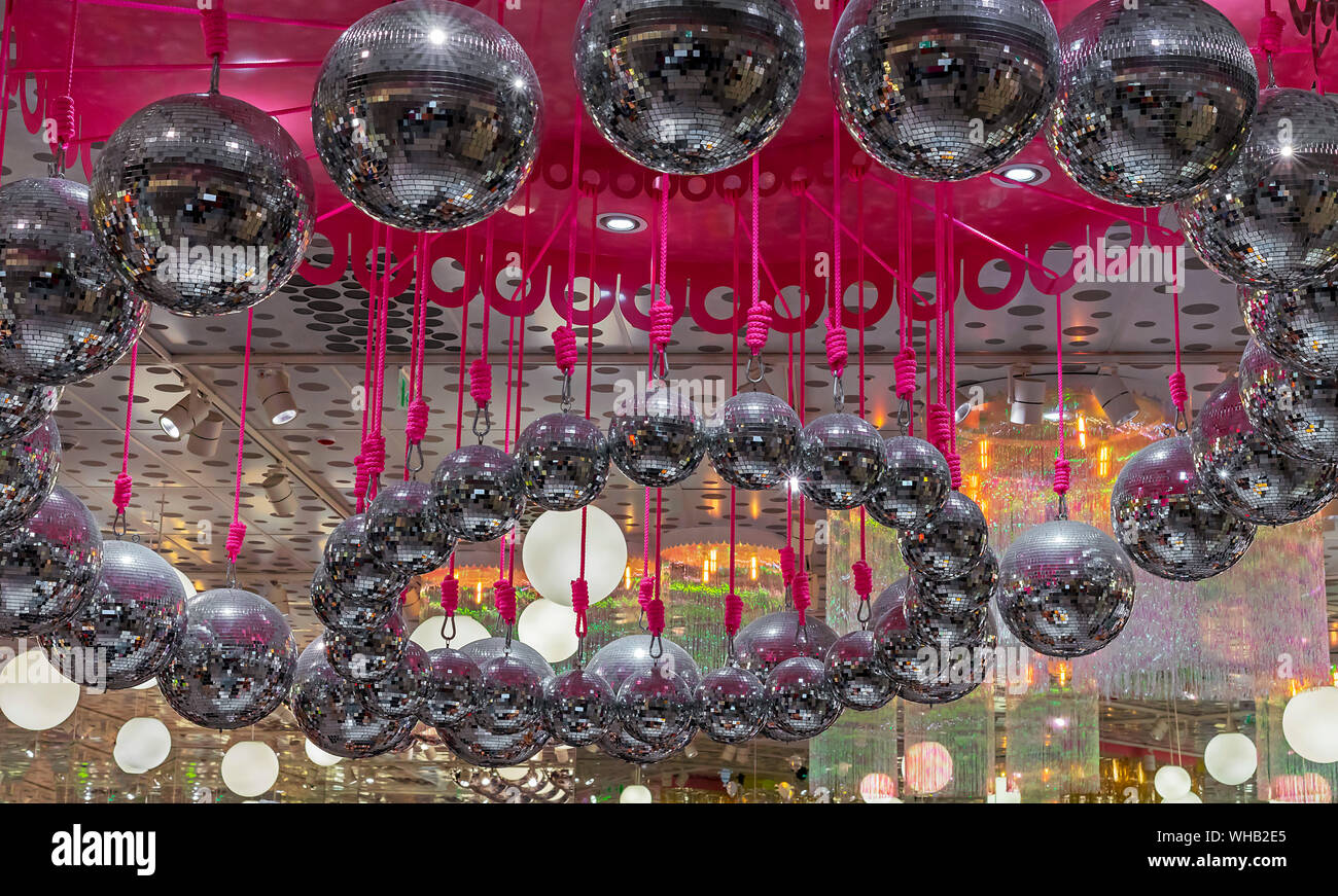 Disco balls hang on pink ropes. Background with a lot of disco balls ...
