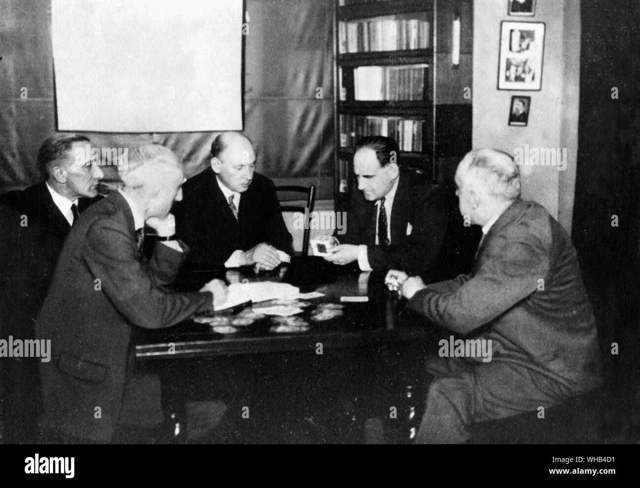 An experiment in telepathy - Dr. Seal (centre) and Harry Price test Fred Marion, who is sensing the value and colour of a playing card from its back.. Stock Photo