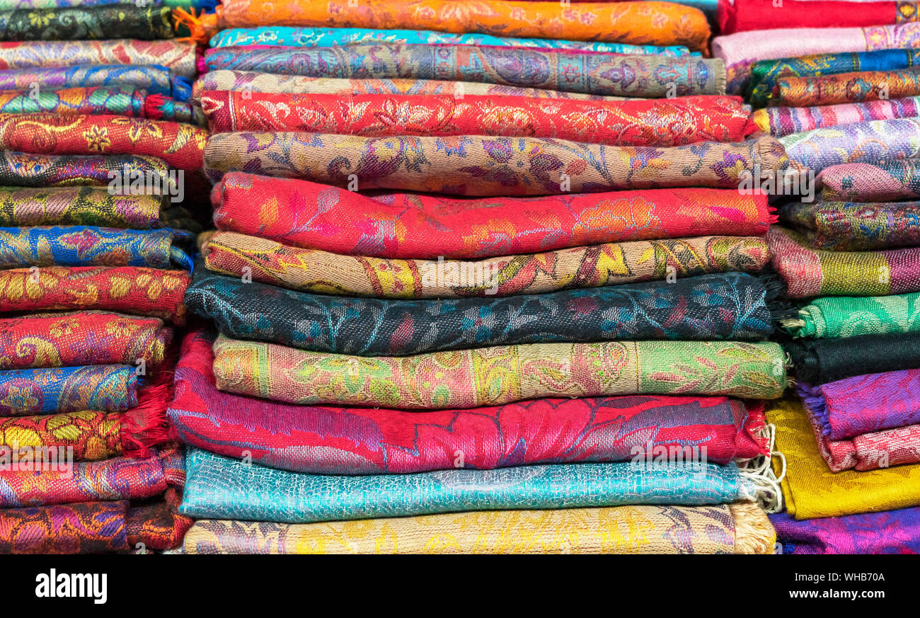 Bright cashmere shawls in the bazaar. Background with oriental shawls ...