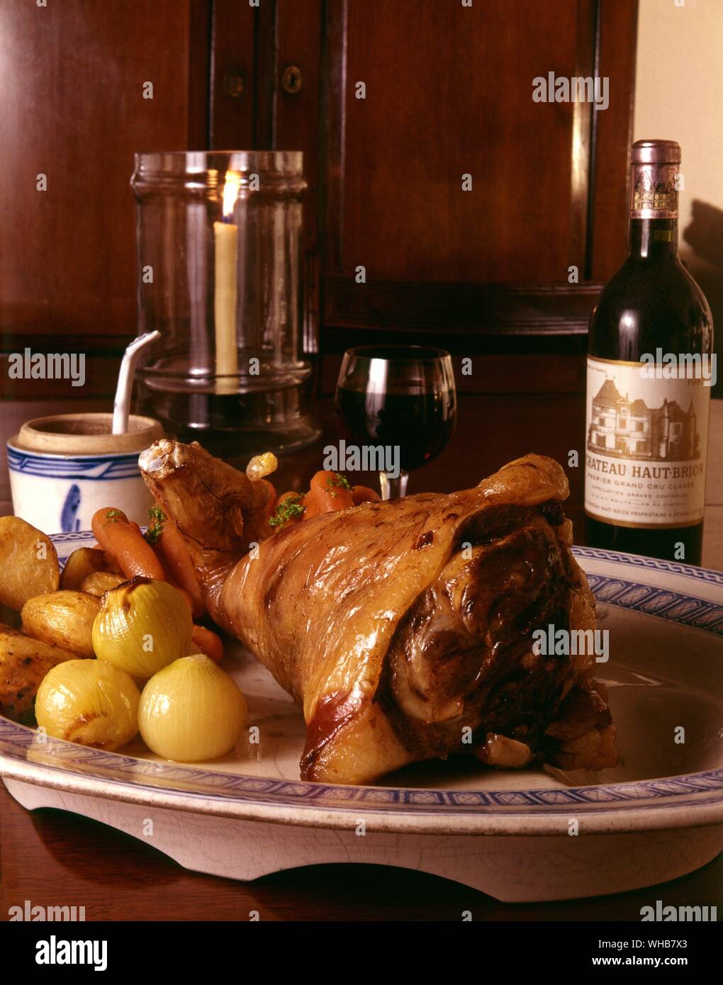 Leg of lamb on a serving platter with veg. Stock Photo