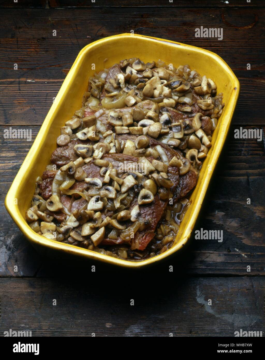 Mushrooms onions and chops in a dish. Stock Photo