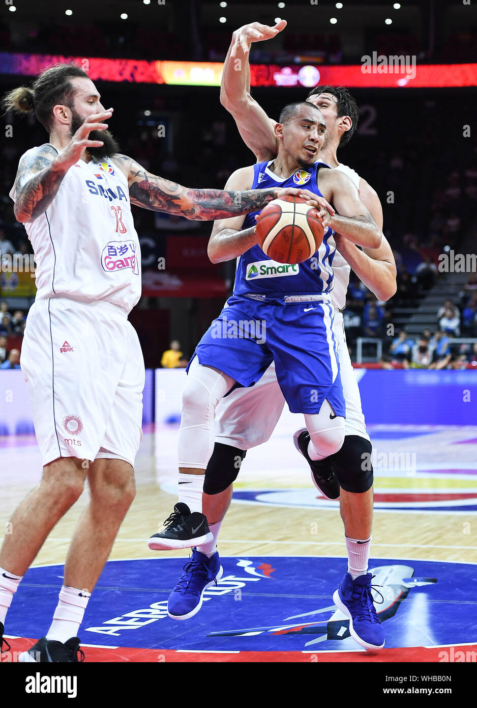 (190902) -- FOSHAN, Sept. 2, 2019 (Xinhua) -- Paul John Dalistan (front R) of the Philippines grabs the ball during the group D match between Serbia and the Philippines at the 2019 FIBA World Cup in Foshan, south China's Guangdong Province, Sept. 2, 2019. (Xinhua/Xue Yubin) Stock Photo