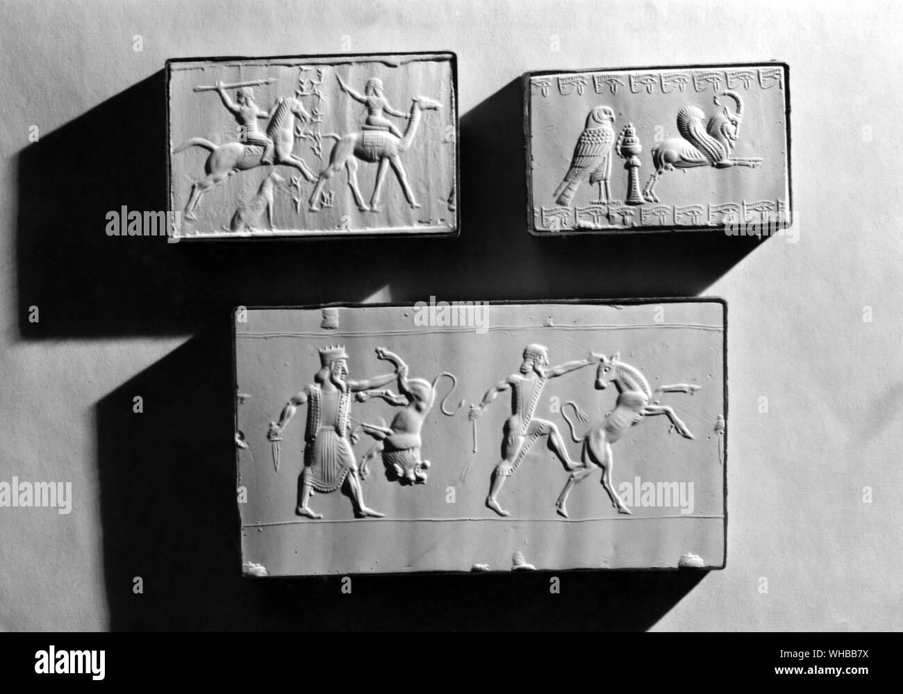Middle Eastern Sculptures in relief : top left - Seal of Ninurta ah iddin ( son of ) Bel napishtimma , NeoBabylonian 6th - 5th Century BC , A cavalry man attacking an Arab with a spear . lower - Royal hunt , Perisan 6th - 5th Century BC , one of the Archaemenid Kings is shown holding a lion by one hind leg , another man catches a bull by the war . These are ancient Assyrian and Babylonian subjects symbolising King triumphing over enemies Stock Photo