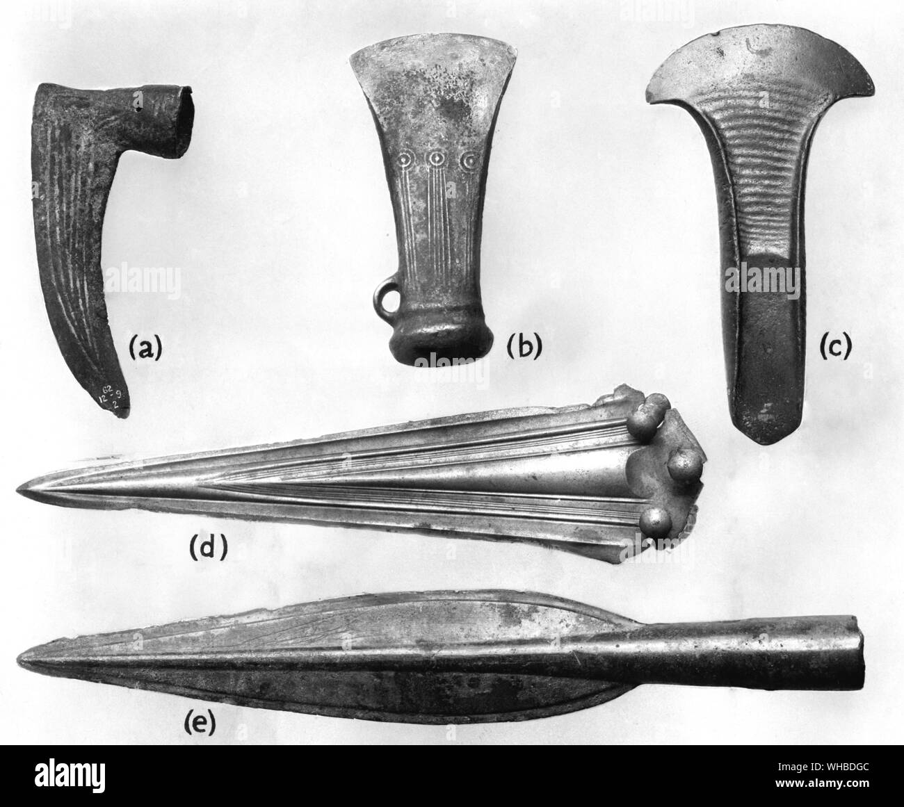 British Bronze Age Implements - a: Flanged axe from the Thames , length 6.3 in b: Socketed axe from Walthamstow Essex length 4.8 in c: Dagger from the Thames length 10.25 in d: Spearhead from the great hoard found in Heathery Burn Cave Co Durham length 12.5 in e: Socketed sickle British type length 5.0 in Stock Photo