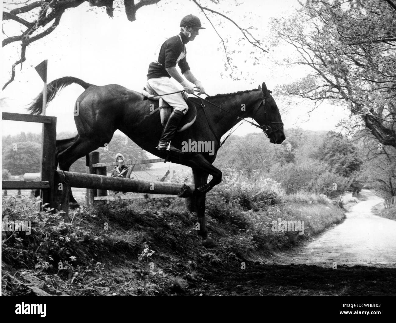 Clearing the rail into the sunken road fence on the 1967 Tidworth Cross Country Course is Mark Phillips riding Rock On Stock Photo