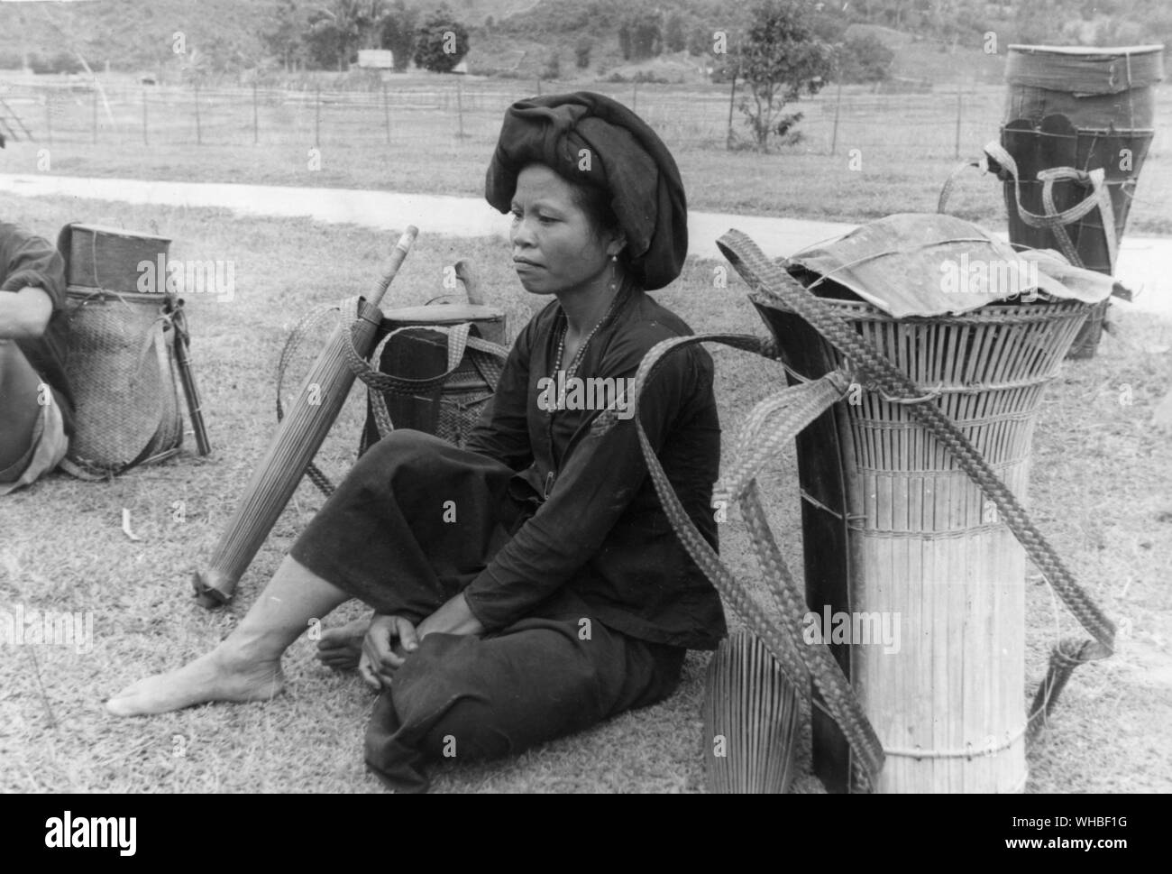 Woman resting besides her Buhungan  or carrying basket of split bamboo North Borneo . Stock Photo