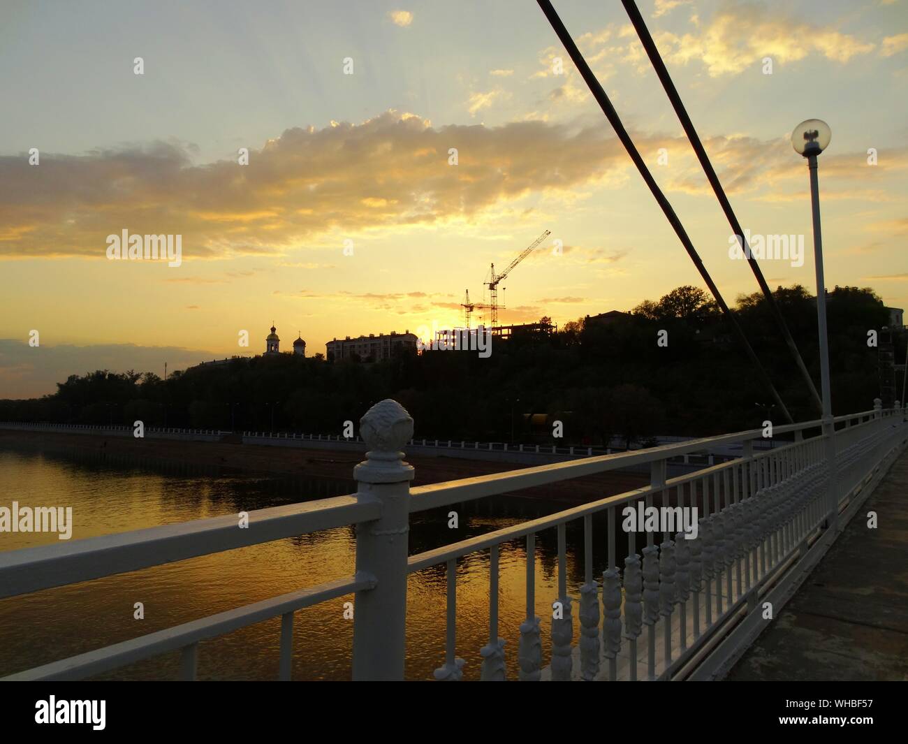Bridge Over Ural River Against Sky During Sunset Stock Photo