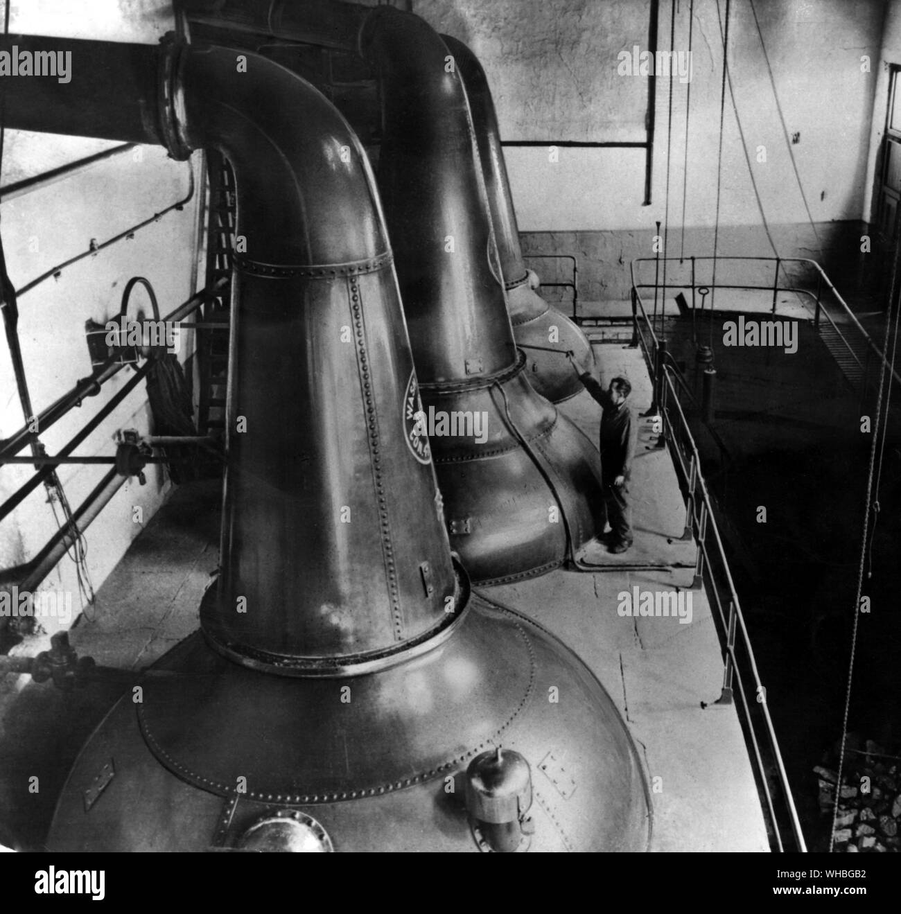 Whiskey Production : In these stills the fermented liquor is vaporised . The vaporised liquid from the first still is conducted into a second and smaller still for a second distilling Stock Photo