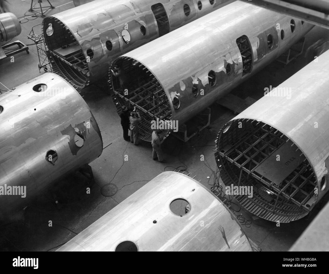 Aircraft Production : Huge hanger at Filton Bristol , displaying fuselages ready for the production of the Bristol Britannia Mark 100 prop jet airliners , to carry 92 passengers and used on Commonwealth air routes . After the fuselage section has been removed form the jig , work proceeds on the floor structures , installations and services . Stock Photo