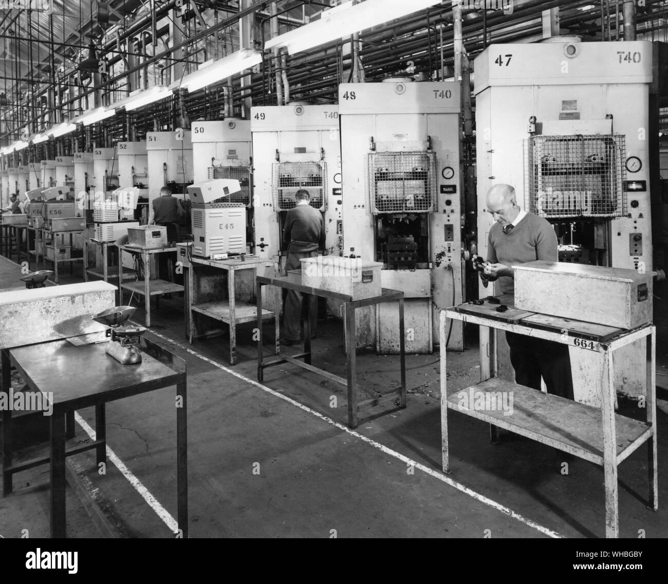 A line of 40 ton semi automatic Bipel presses suitable for use in producing small electrical components . The bench apparatus alongside press 49 is a high frequency heater used to preheat the moulding component . The line was in use in December 1960 at the National Plastics Plant in Avenue Works , London , E4 , England . Stock Photo