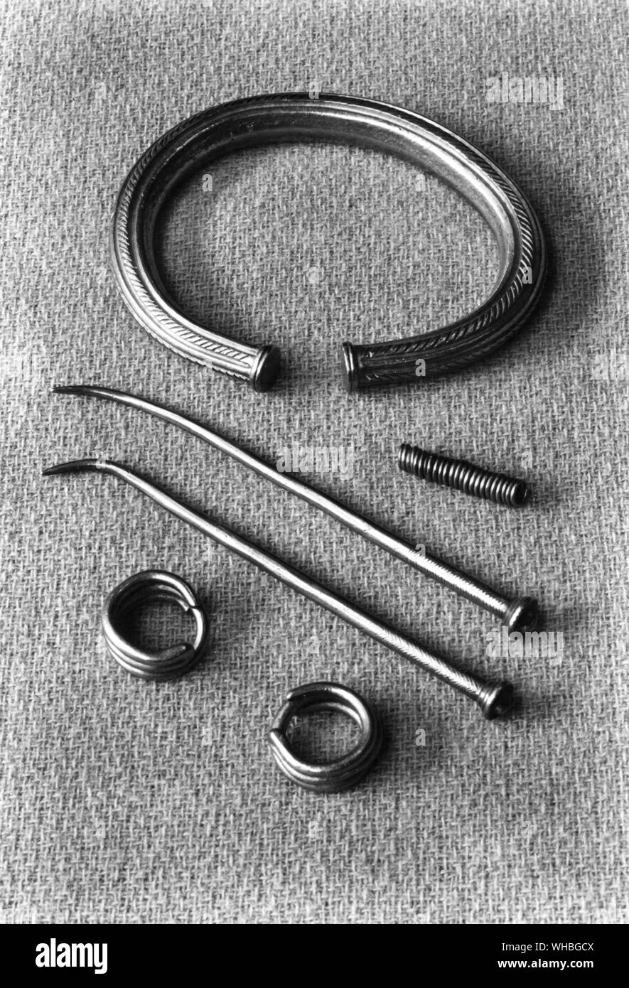 Gold ornaments from a Chieften's tumulus at Lembingen. A massive chased bracelet wound hair ring. Pair of loop headed pins and a pair of recurved finger rings. Stock Photo