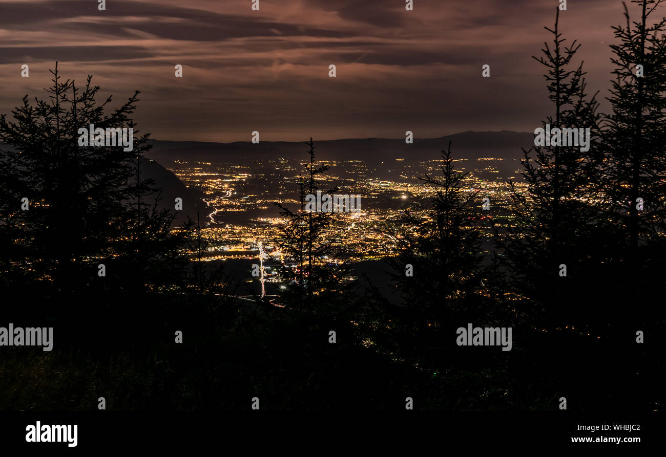 Evening top view of the city lights,French Annemasse, Swiss Geneva,dark sky background, photo with long exposure.Department of Haute-Savoie in France. Stock Photo
