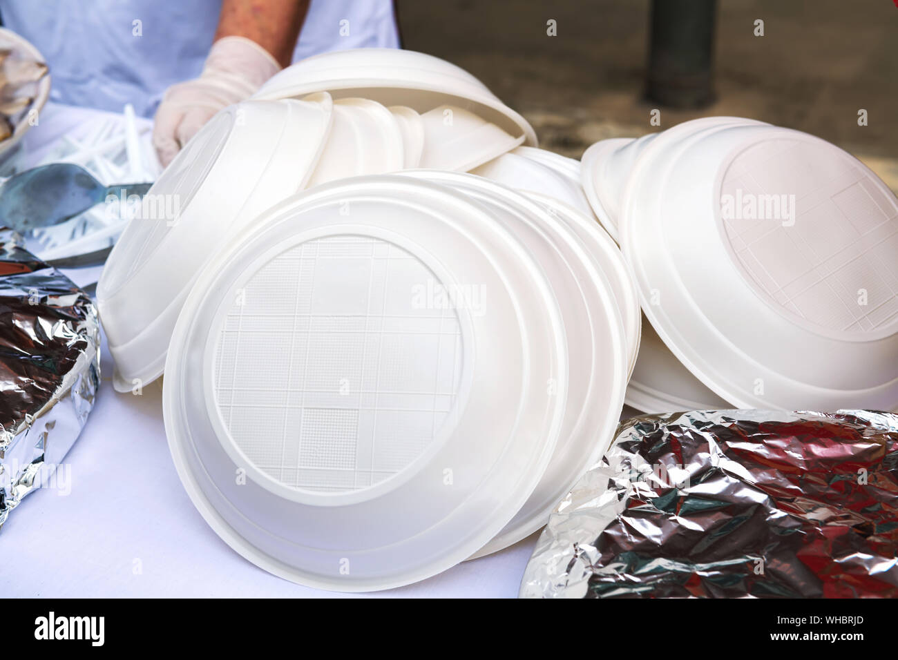A pile of plastic plates on the street. Ban disposable plastic utensils