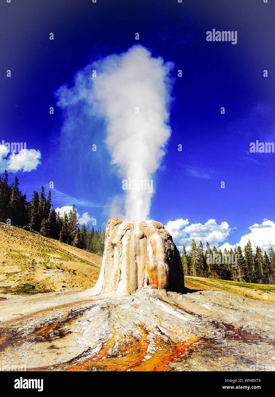 Lone Star Geyser Against Blue Sky At Yellowstone National Park Stock Photo
