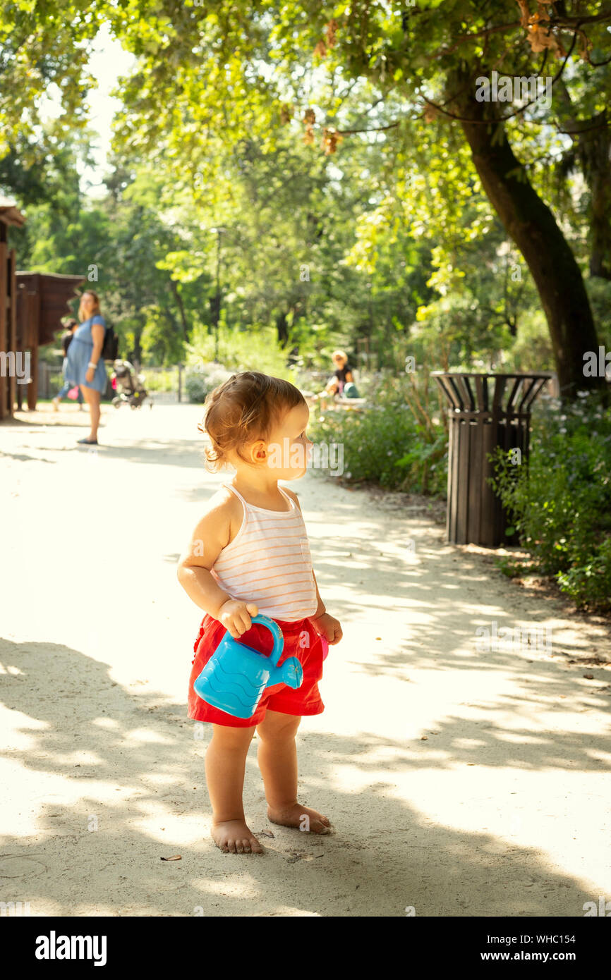 Cute kid with watering can in a playground Stock Photo