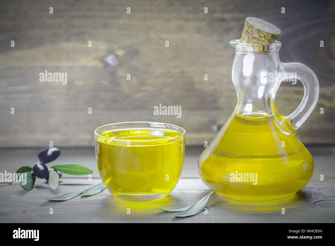 Olive oil and olive branch on the wooden table, Italian food