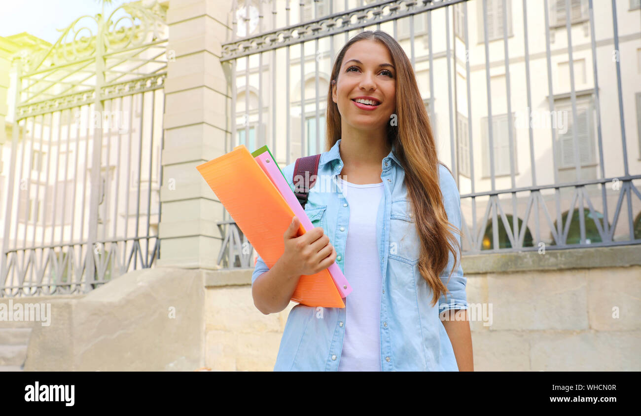 Happy student girl looking in front of her outdoors. Copy space. Stock Photo