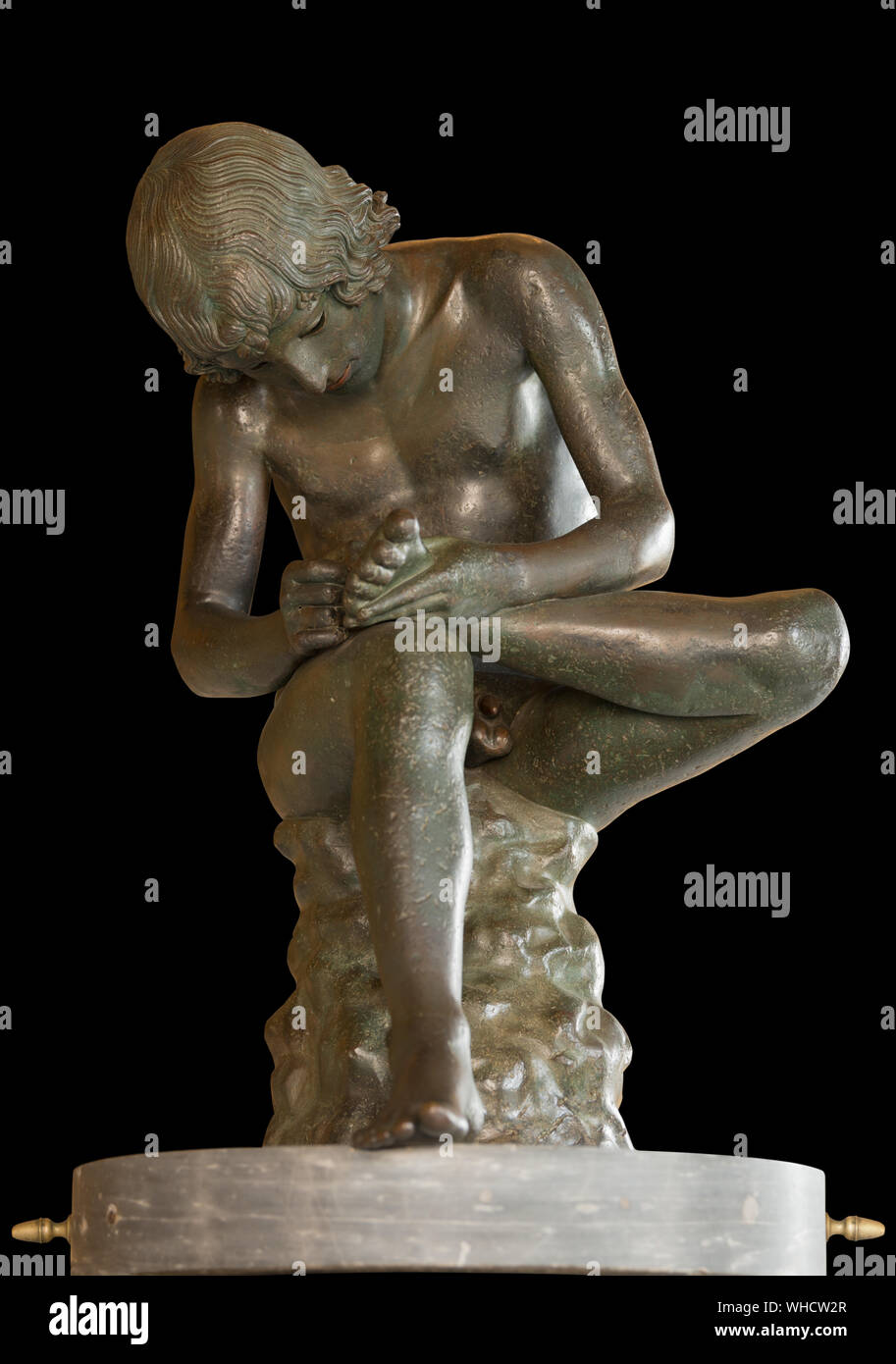 Boy with Thorn, bronze statue in Capitoline Museums, Rome, Italy. 1st century BC. Isolated on black Stock Photo