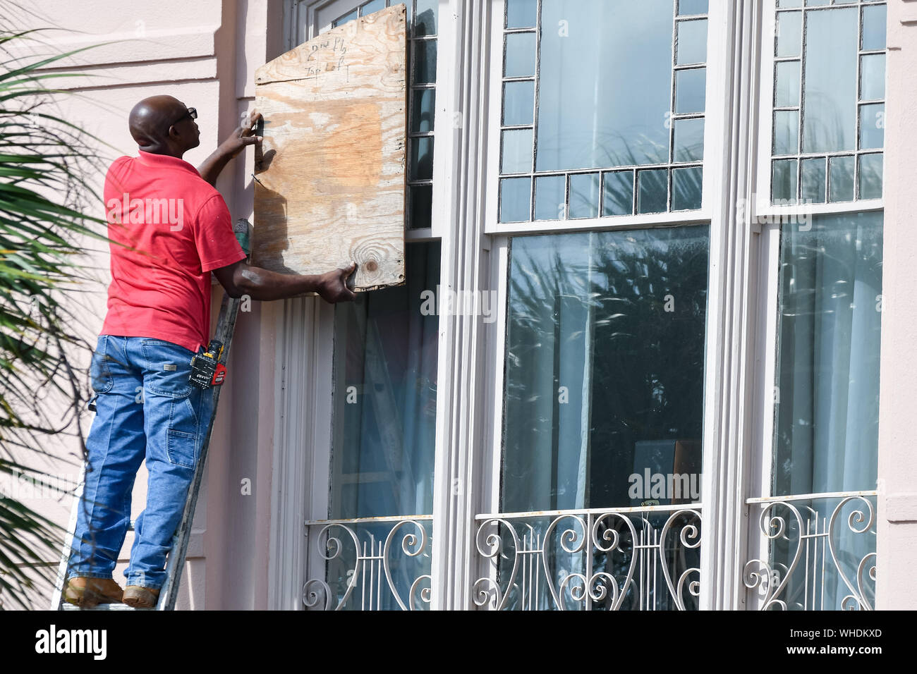 Charleston, South Carolina, USA. 02nd Sep, 2019. A worker covers windows on a historic home with plywood in preparation for Hurricane Dorian on Monday, September 2, 2019 in Charleston, South Carolina. The monster Category 5 storm devastated the Bahamas and is expected to weaken and then move north along the Eastern Seaboard.  Photo by Richard Ellis/UPI Credit: UPI/Alamy Live News Stock Photo
