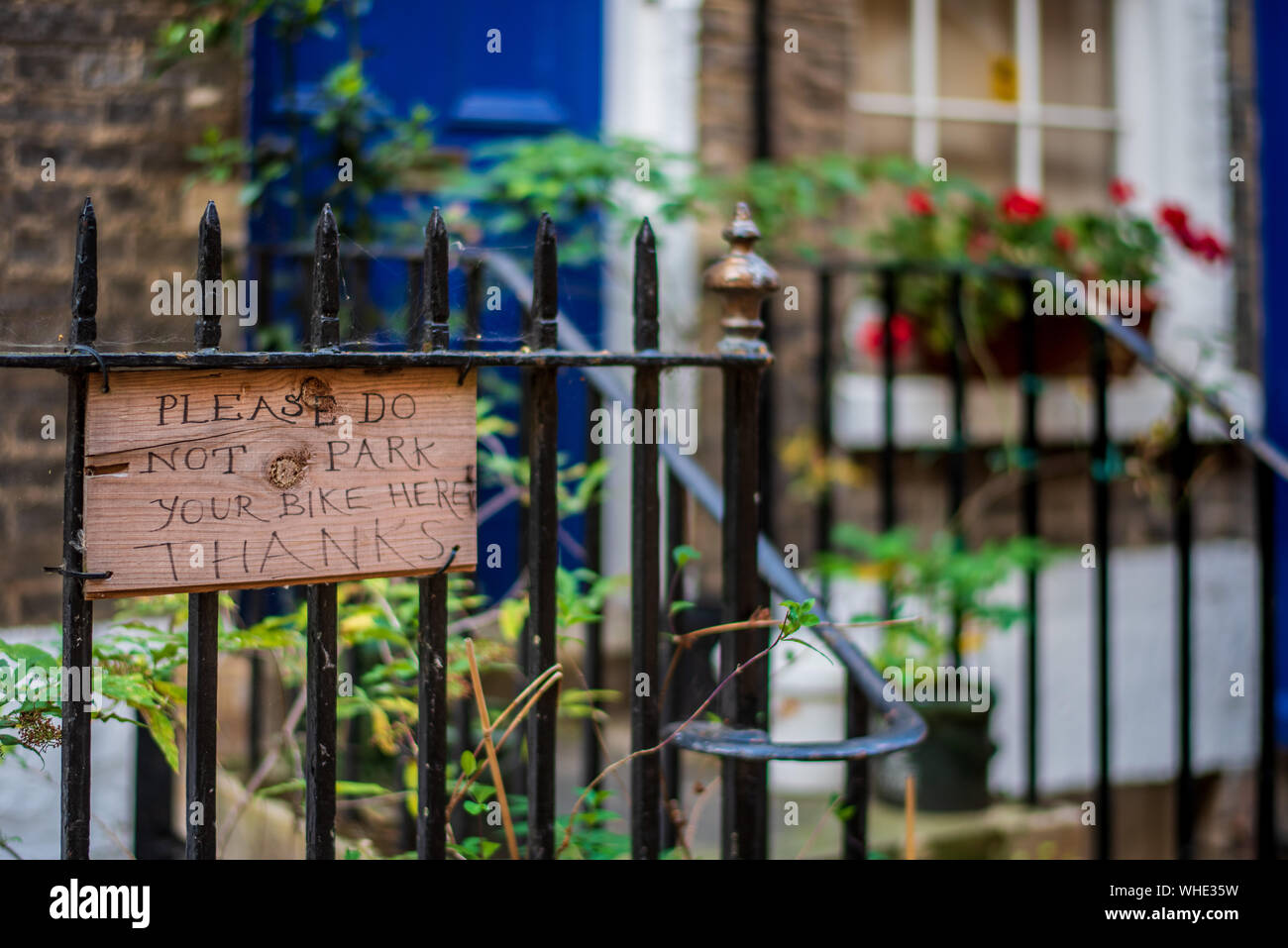 Quirky Cambridge - hand made sign requesting 'Please do not park your bike here Thanks' on railings outside a house in central Cambridge UK Stock Photo