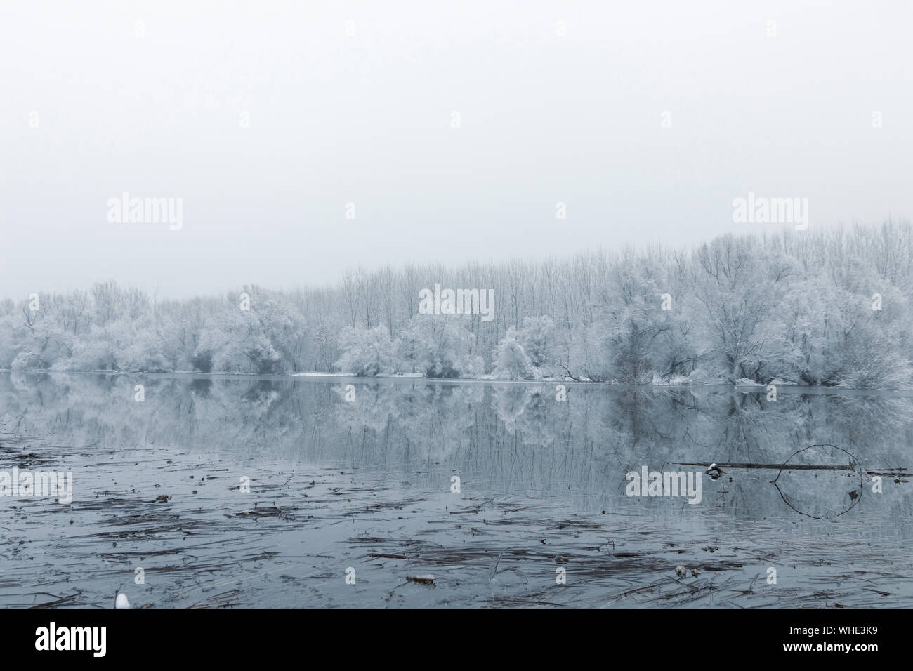 Frozen lake in winter, Winter lake scene reflecting in the water Stock