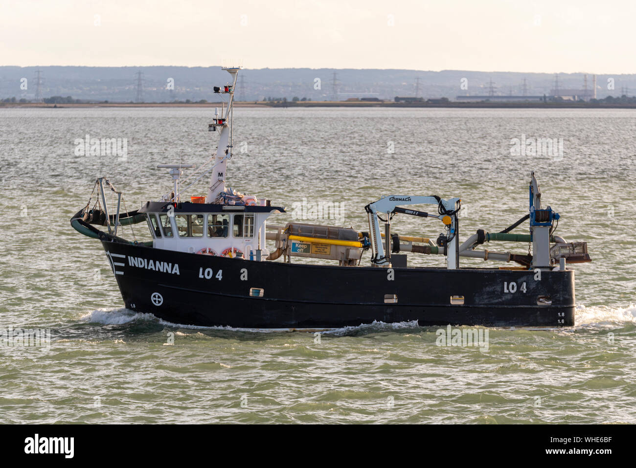 Fishing boat Indianna heading out to sea to fish late afternoon for the night out of Leigh on Sea passing Southend on the Thames Estuary. Industry Stock Photo