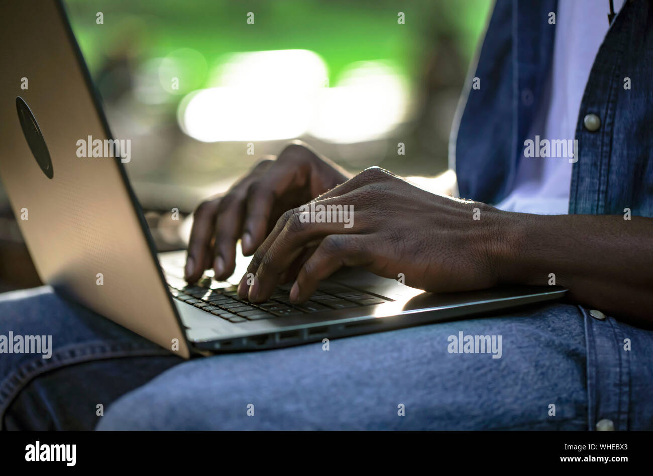 Closeup of african male working by laptop outdoors Stock Photo