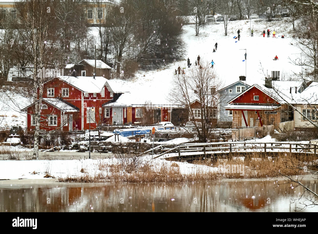 Local people are sledding at old historic Porvoo, Finland. Traditional  Scandinavian rural red wooden houses and old river bridge under white snow.  Sno Stock Photo - Alamy