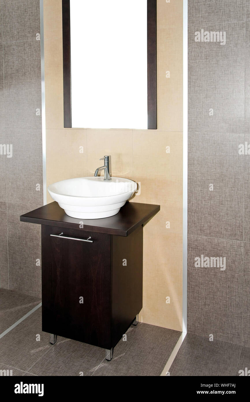 Contemporary Lavatory With Brown Cabinet And Mirror Stock Photo