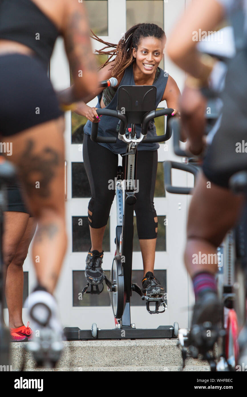 An instructor leads an outdoor spin class as part of the Pretty Girls Sweat Festival, a fitness expo for women in Atlanta on September 15, 2018. Stock Photo