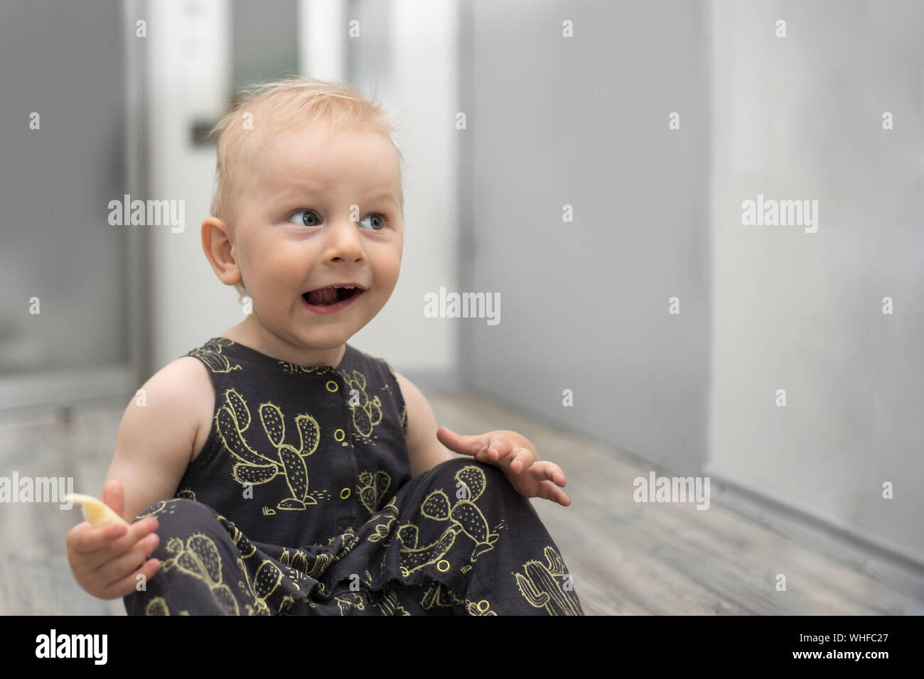 Surprised Little Baby on Floor in Home Interior Stock Photo