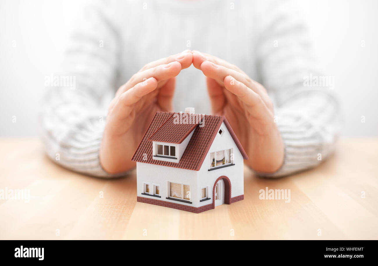 House miniature covered by hands Stock Photo