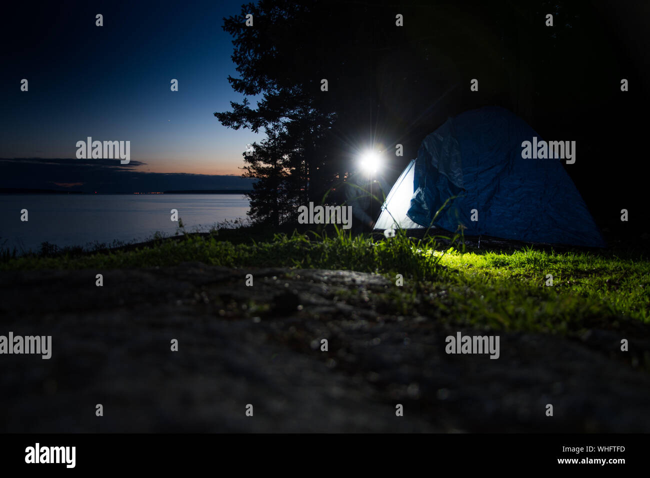 Woman Camping On Field At Night Stock Photo