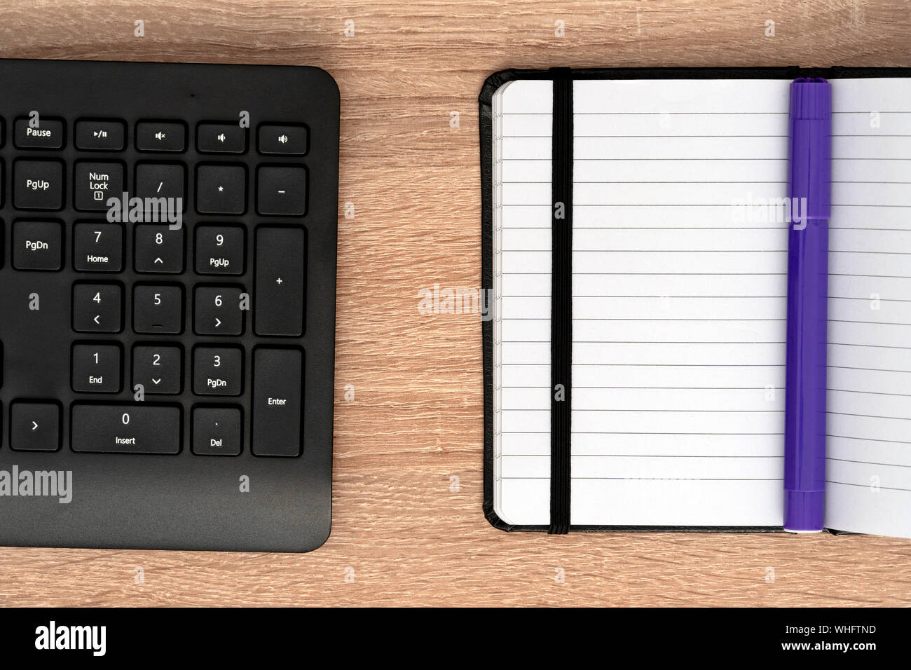 Blue marker on open notepad and keyboard Stock Photo