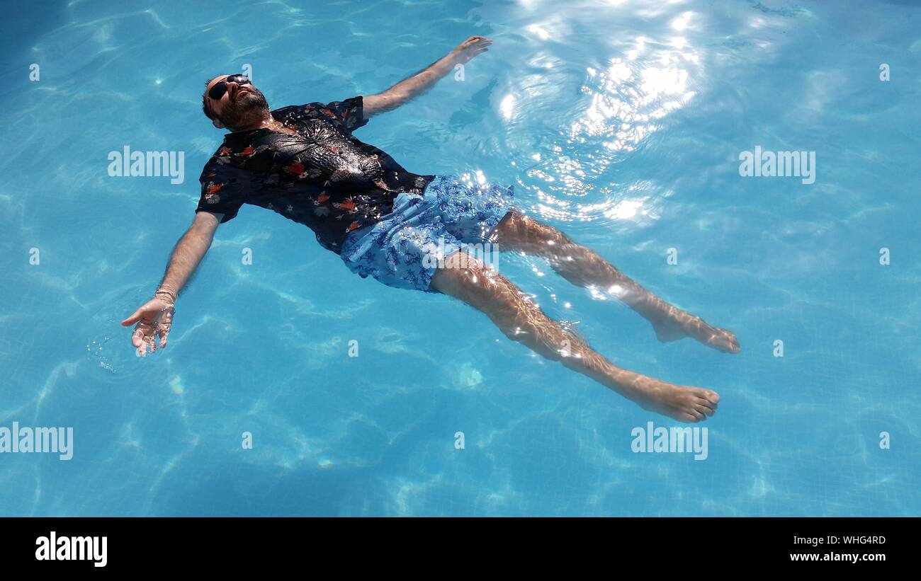 High Angle View Of Man Floating On Water Stock Photo