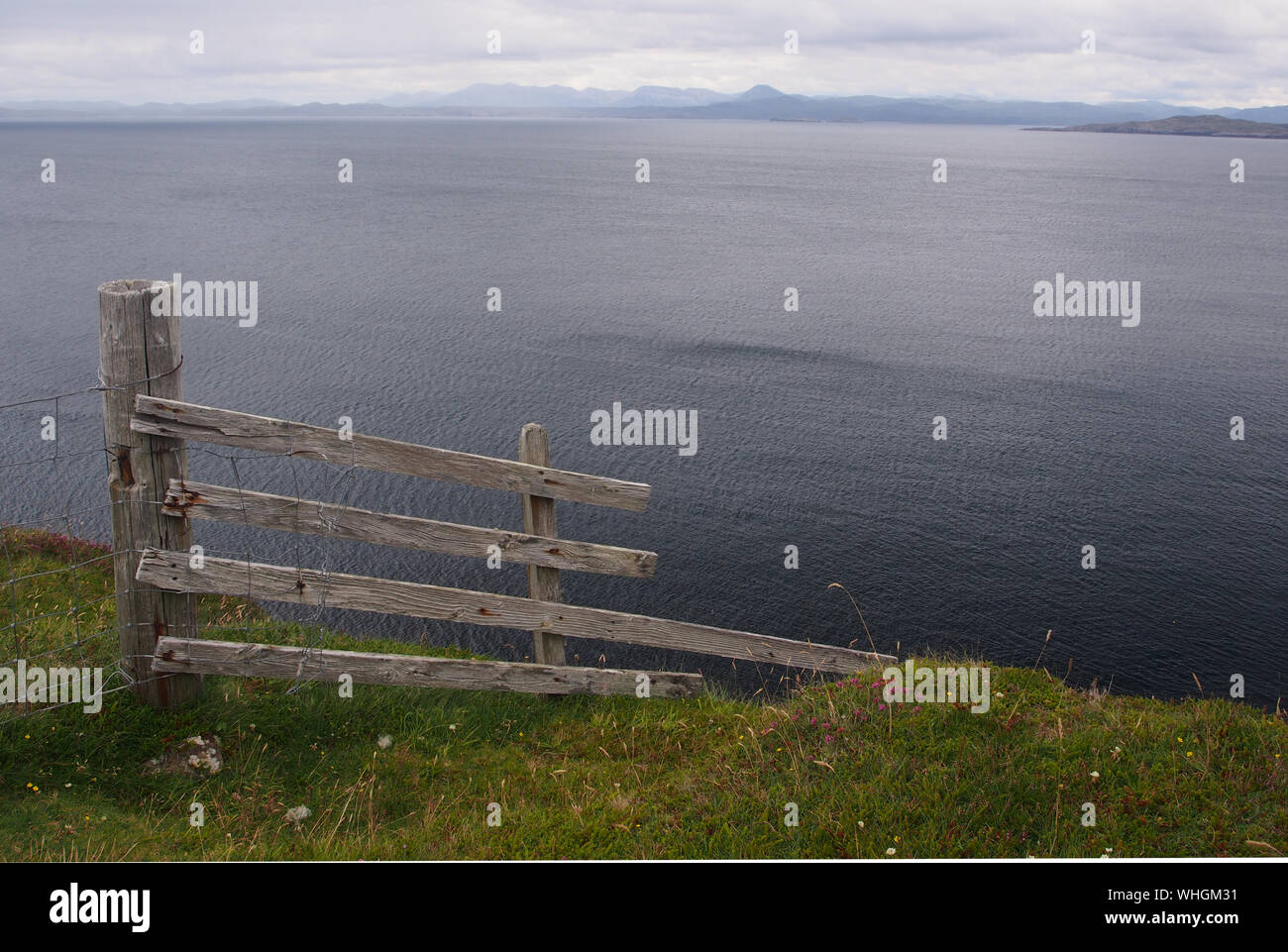 A view out to sea at the end of the stoer peninsula, Sutherland, Scotland with a fence post and fence end pointing down the cliff to the sea Stock Photo