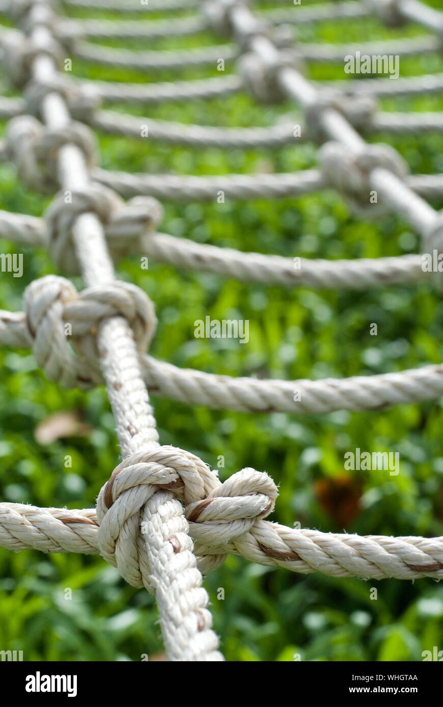 Close-up Of Climbing Rope Over Grassy Field At Playground Stock Photo