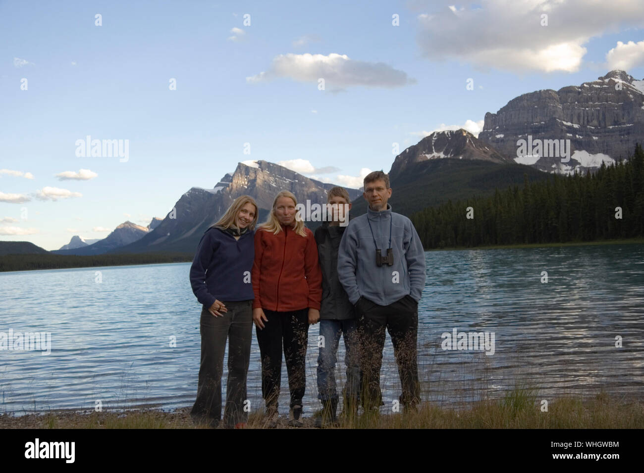 Portrait Of Family Standing By Lake Waterfowl Against Sky At Banff National Park Stock Photo