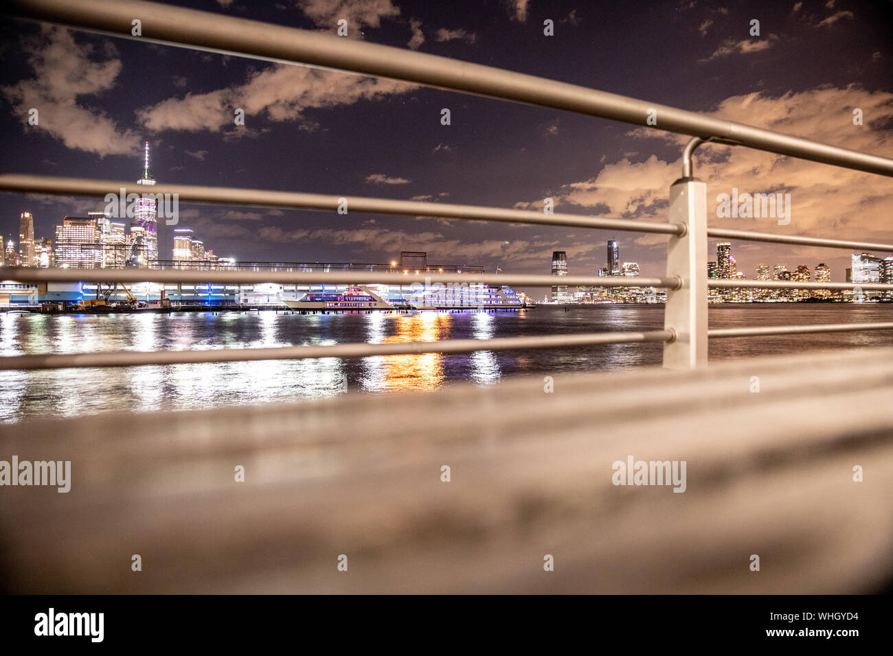 New York City view of skyline seen through railing on pier Stock Photo