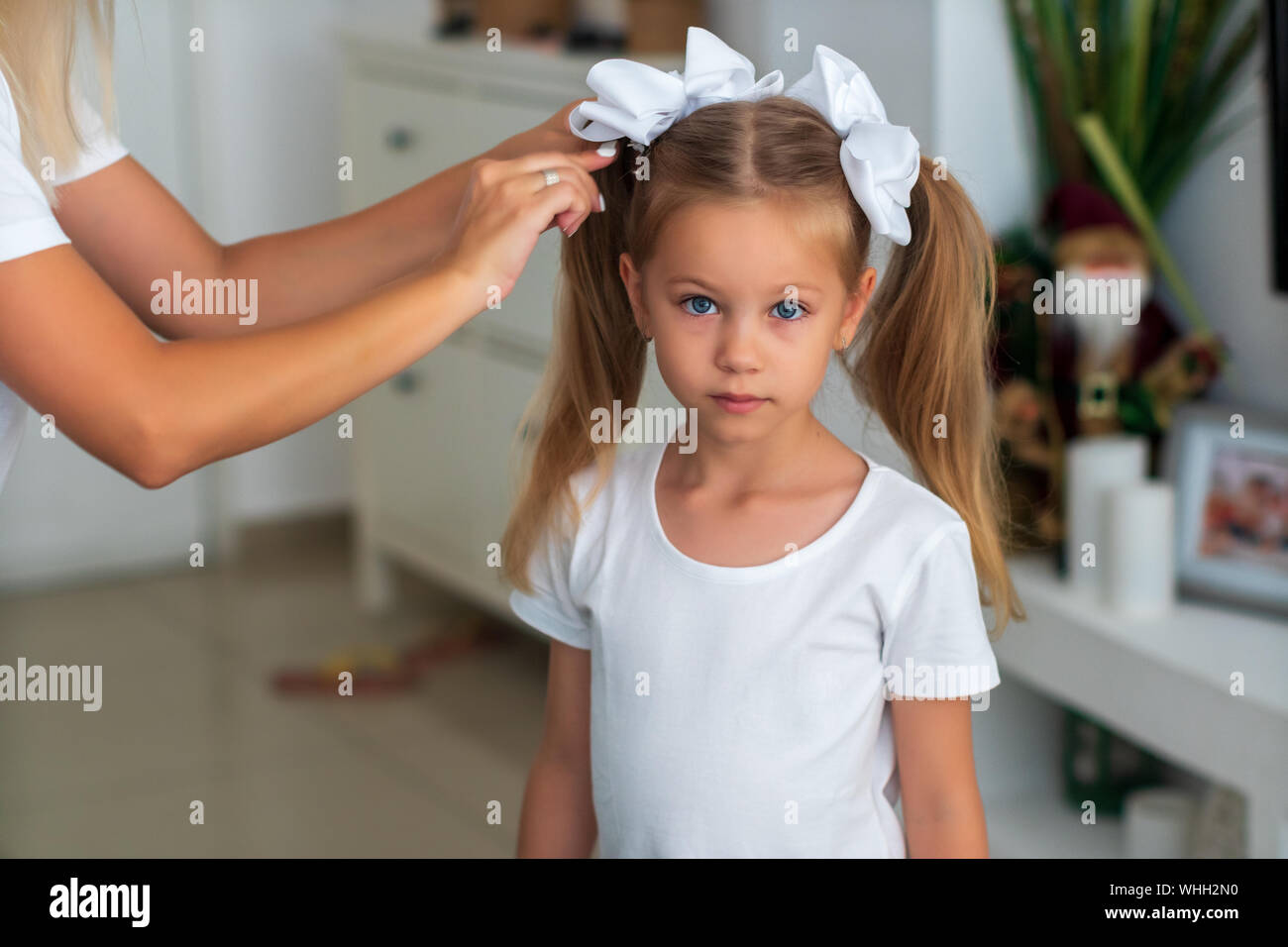 Mother combing her daughter's hair. Hair in hand Stock Photo