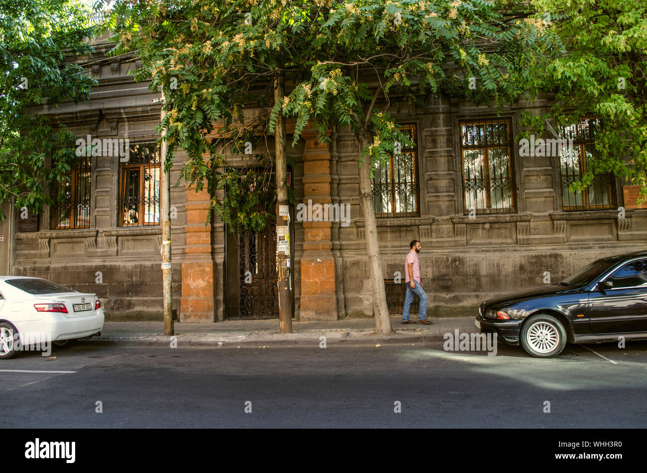 Yerevan, Armenia, 27 August 2019: Old building of black tuff decorated with red tuff with wrought iron bars on the Windows and doors on Khorenatsi str Stock Photo