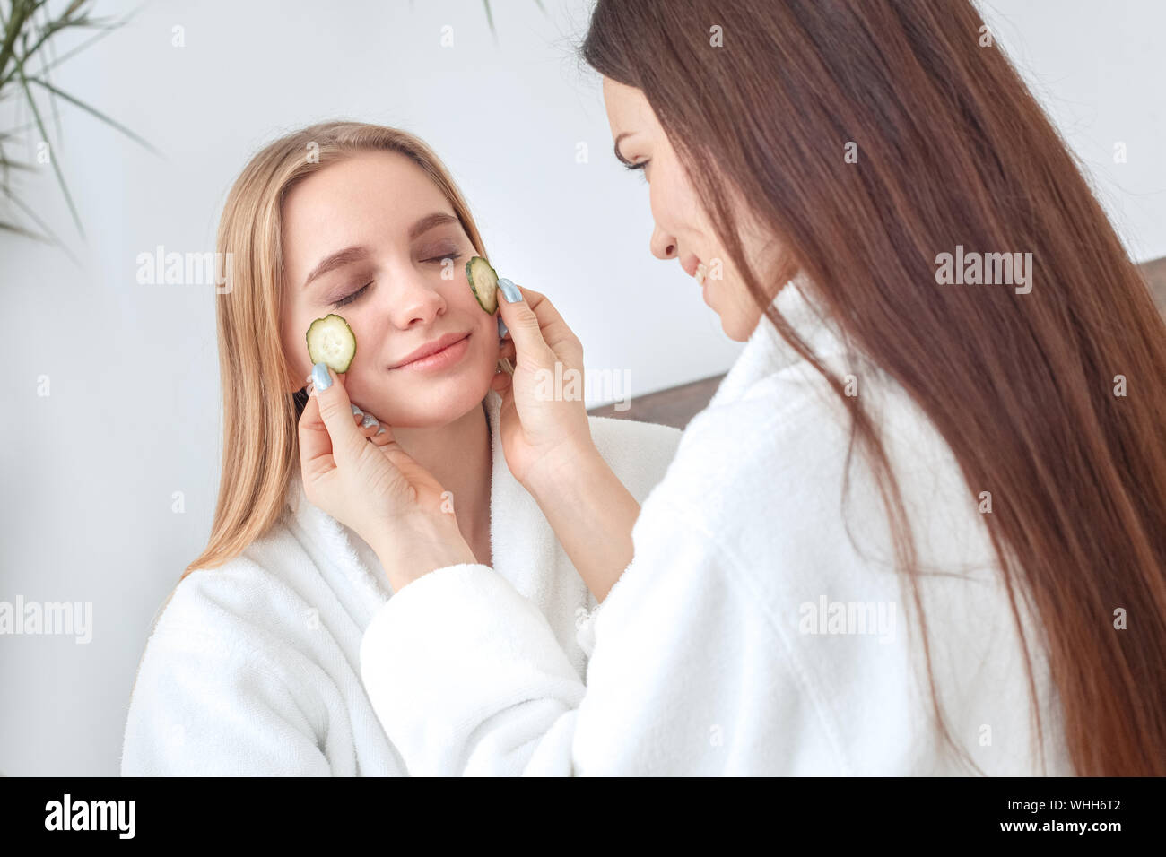 Young Women Rest Together At Home Beauty Care Wearing Bath Robes