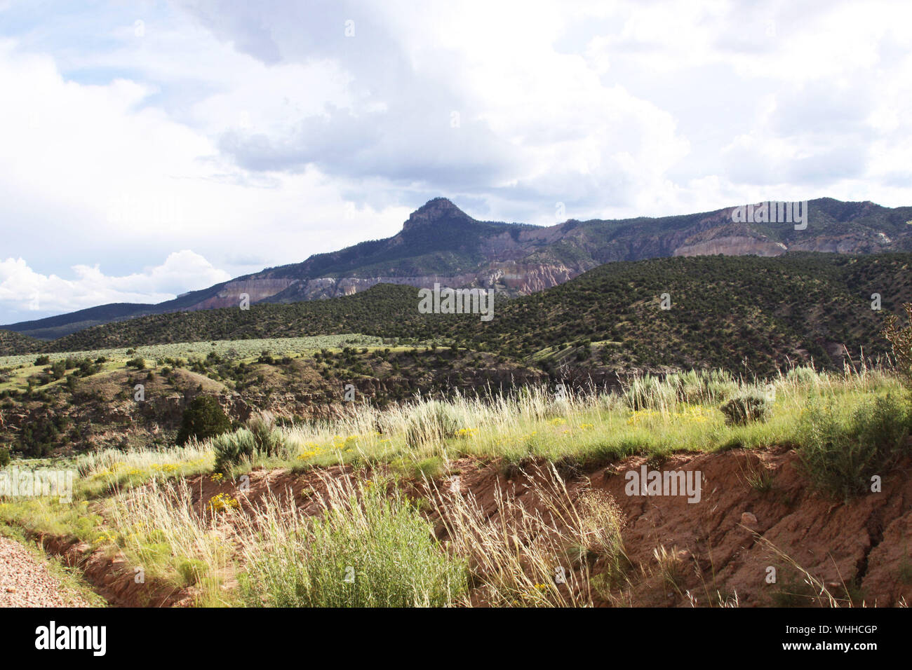 Wide View Of Rocky Mountains Against Cloudy Sky Stock Photo