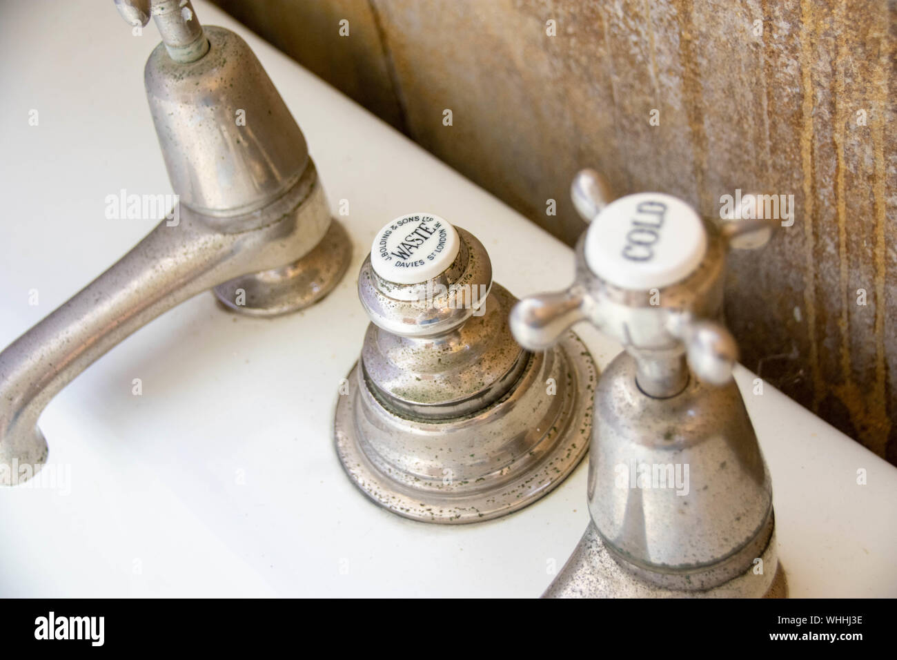 Classic style, antique bathroom taps and waste fixtures and fittings from the early 20th century showing beautiful ageing and patina. Stock Photo